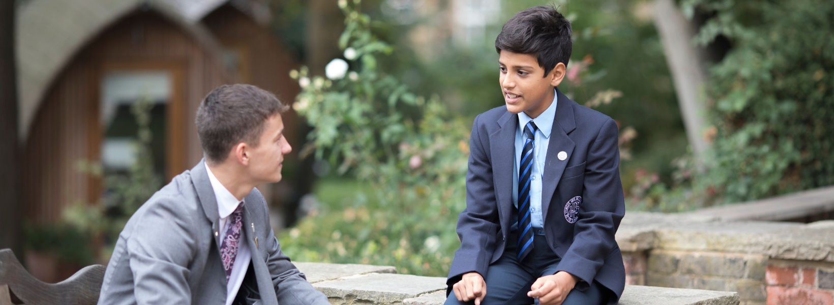 Sixth form pupil talking to a senior pupil at Ibstock Place School, a private school near Richmond, Barnes, Putney, Kingston, and Wandsworth.